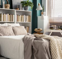 Creative use of small space in a stylish bedroom interior with designer decor and cozy white and beige bedding